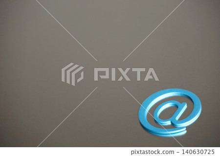 A still life/internet communication concept featuring an "@" symbol clip against a metal plate background. A still life/internet communication concept featuring an "@" symbol clip against a metal plate background. 140630725