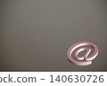 A still life/internet communication concept featuring an "@" symbol clip against a metal plate background. 140630726