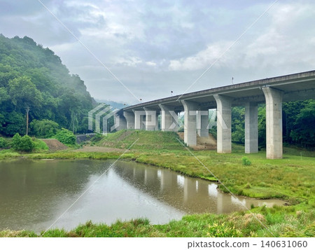 一條公路和一片碧綠的池塘蜿蜒穿過雲霧繚繞的山脈。 一條公路和一片碧綠的池塘蜿蜒穿過雲霧繚繞的山脈。 140631060