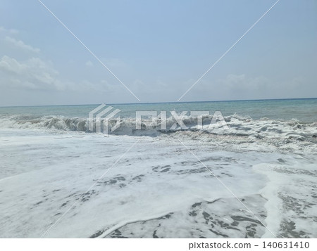 Sea foam splashing on the water's edge at the beach 140631410
