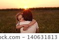 Mother and daughter hug at sunset, Family love in the evening sun, Warm embrace in nature, Parenting moments outdoors, Child comforted by parent, Emotional sunset bonding, Tender moments in a field 140631813