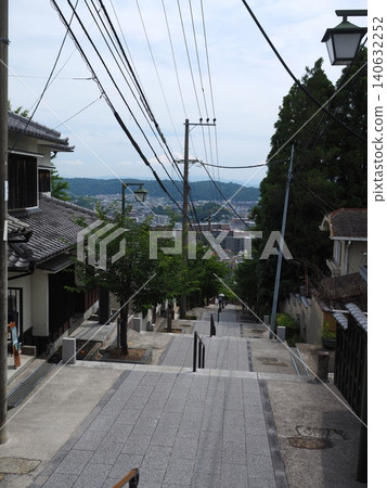 A beautiful view of the stone steps and townscape from the approach to Hozanji Temple on Mount Ikoma in early summer. A beautiful view of the stone steps and townscape from the approach to Hozanji Temple on Mount Ikoma in early summer. 140632252