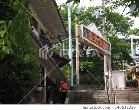 寶山寺商店街上的「旅遊生駒」牌坊被初夏的清新綠意所環繞。 寶山寺商店街上的「旅遊生駒」牌坊被初夏的清新綠意所環繞。 140632286