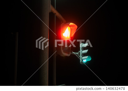 A scene of a nighttime intersection with vertical traffic lights designed for snowy regions lit up in red. A scene of a nighttime intersection with vertical traffic lights designed for snowy regions lit up in red. 140632478