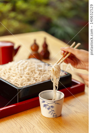 日式餐廳場景,人們在木桌旁用筷子吃蕎麥麵。 日式餐廳場景,人們在木桌旁用筷子吃蕎麥麵。 140632529