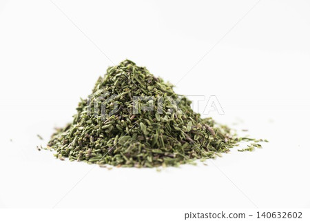 A pile of dried thyme spice is placed against a white background. A pile of dried thyme spice is placed against a white background. 140632602