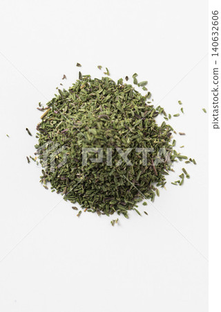 A pile of dried thyme spice is placed against a white background. A pile of dried thyme spice is placed against a white background. 140632606
