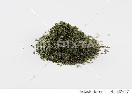 A pile of dried thyme spice is placed against a white background. A pile of dried thyme spice is placed against a white background. 140632607