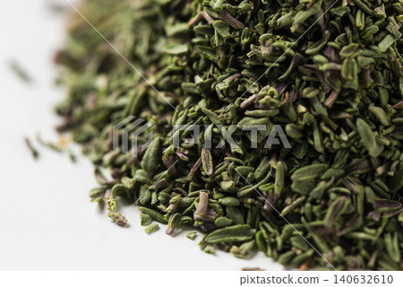 A pile of dried thyme spice is placed against a white background. A pile of dried thyme spice is placed against a white background. 140632610