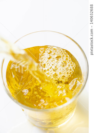 冰涼的琥珀色茶水倒入裝滿冰塊的玻璃杯中。 冰涼的琥珀色茶水倒入裝滿冰塊的玻璃杯中。 140632688