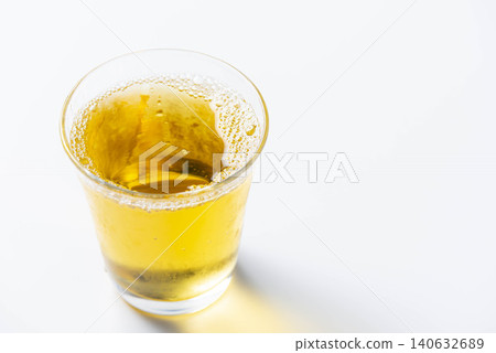 冰涼的琥珀色茶水倒入裝滿冰塊的玻璃杯中。 冰涼的琥珀色茶水倒入裝滿冰塊的玻璃杯中。 140632689