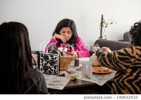 A girl in a pink shirt sits at a table with a basket and a book A girl in a pink shirt sits at a table with a basket and a book 140632910