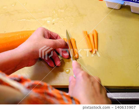 A woman cooking carrots A woman cooking carrots 140633907