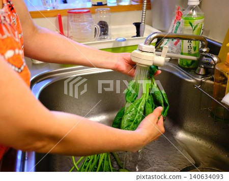 Woman washing spinach Woman washing spinach 140634093