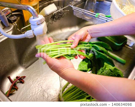 Woman washing spinach Woman washing spinach 140634098