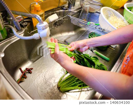Woman washing spinach Woman washing spinach 140634100