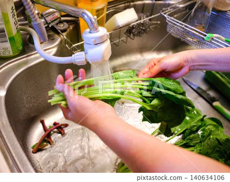 Woman washing spinach 140634106