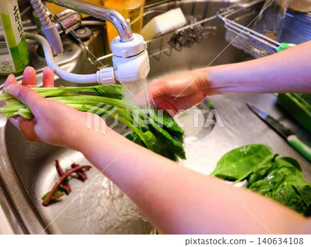 Woman washing spinach Woman washing spinach 140634108