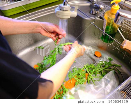 Woman washing spinach Woman washing spinach 140634529