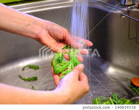 Woman washing spinach Woman washing spinach 140634538
