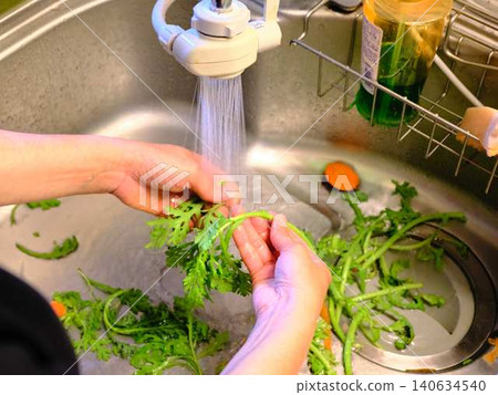 Woman washing spinach Woman washing spinach 140634540