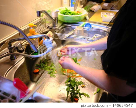 Woman washing spinach Woman washing spinach 140634547