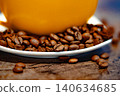 Cup of coffee and coffee beans on a white plate. dark background 140634685