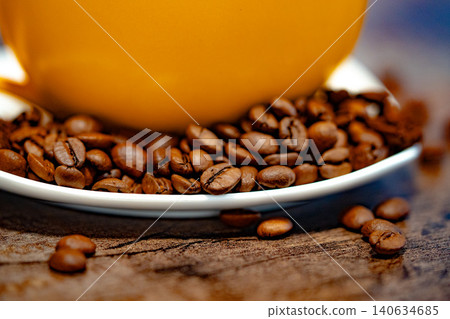 Cup of coffee and coffee beans on a white plate. dark background Cup of coffee and coffee beans on a white plate. dark background 140634685