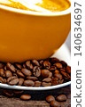 Cup of coffee and coffee beans on a white plate. dark background 140634697