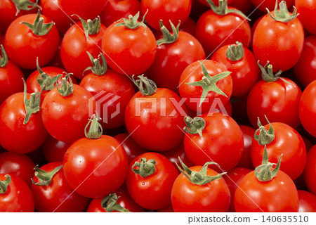 A landscape of abundant red produce, with fresh tomatoes piled high. 140635510