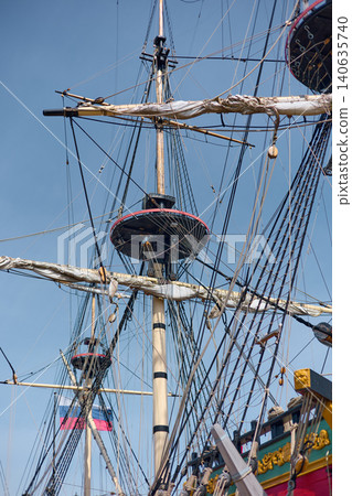 moored replica of an ancient sailing frigate in yacht club in Saint-Petersburg - Russia at clear sunny weather, huge masts, thick ropes moored replica of an ancient sailing frigate in yacht club in Saint-Petersburg - Russia at clear sunny weather, huge masts, thick ropes 140635740