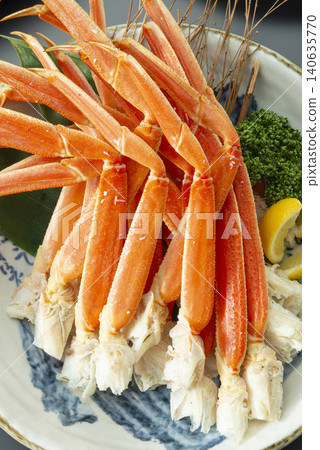 A dish featuring plenty of boiled snow crab legs served on a Japanese plate, garnished with lemon. A dish featuring plenty of boiled snow crab legs served on a Japanese plate, garnished with lemon. 140635770