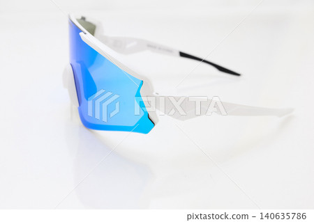 stylish sunglasses on a glossy white table, blue glass, white sunglasses frame, yachting glasses, cycling glasses, reflection on a glossy surface stylish sunglasses on a glossy white table, blue glass, white sunglasses frame, yachting glasses, cycling glasses, reflection on a glossy surface 140635786