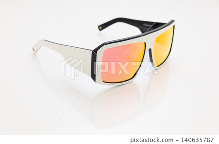 stylish sunglasses on a glossy white table, red orange glass, white sunglasses frame, yachting glasses, cycling glasses, reflection on a glossy surface stylish sunglasses on a glossy white table, red orange glass, white sunglasses frame, yachting glasses, cycling glasses, reflection on a glossy surface 140635787