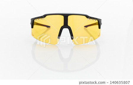 stylish sunglasses on a glossy white table, yellow glass, black sunglasses frame, yachting glasses, cycling glasses, reflection on a glossy surface stylish sunglasses on a glossy white table, yellow glass, black sunglasses frame, yachting glasses, cycling glasses, reflection on a glossy surface 140635807
