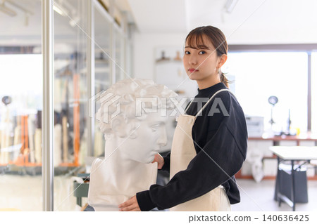 A young female artist touching a plaster cast A young female artist touching a plaster cast 140636425