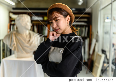 一位年輕女子在她的工作室裡沉思。 140636427