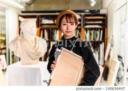 一位女子在工作室手持畫架的肖像 140636447