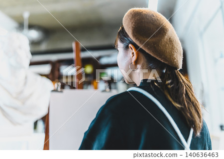 一位女士在工作室裡凝視著一個石膏模型。 一位女士在工作室裡凝視著一個石膏模型。 140636463
