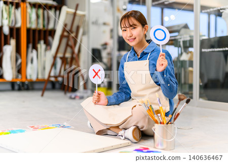 A woman smiling in her studio, holding correct/incorrect tags. A woman smiling in her studio, holding correct/incorrect tags. 140636467