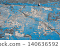 The blue paint is peeling off the cracked asphalt ground. 140636592