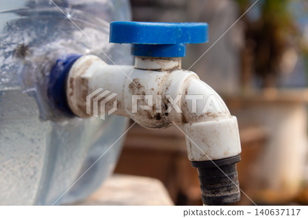 Close Up of Plastic Water Container Faucet with Blue Valve Handle for Clean Water Distribution 140637117