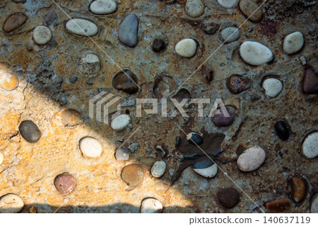 Natural Exposed Aggregate Concrete Texture with Embedded Pebbles and Stones Background Natural Exposed Aggregate Concrete Texture with Embedded Pebbles and Stones Background 140637119