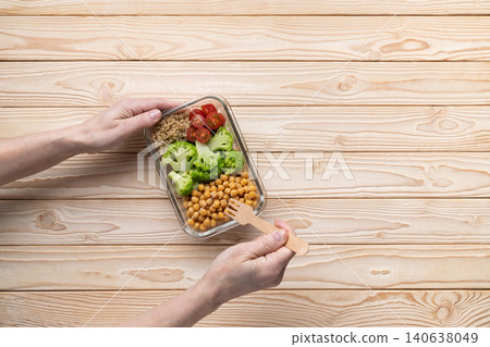 Hands eating healthy meal prep lunch Hands eating healthy meal prep lunch 140638049