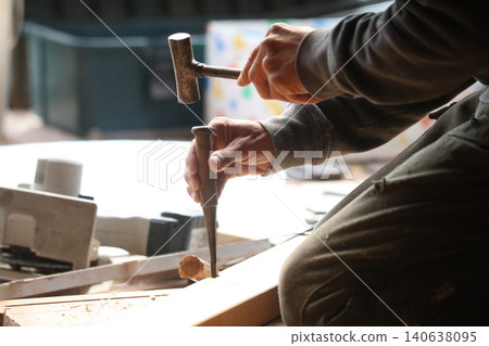 A man cutting wood with a chisel 140638095