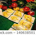 Fresh durian and sliced tropical fruits in plastic containers for sale at a Thai market 140638501