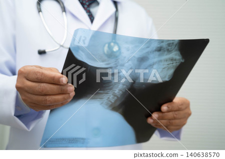 Doctor examining cervical vertebrae bone radiography xray film. Doctor examining cervical vertebrae bone radiography xray film. 140638570