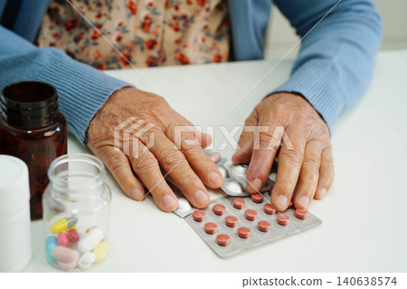 Asian elderly woman holding pill drug in hand, strong healthy medical. Asian elderly woman holding pill drug in hand, strong healthy medical. 140638574