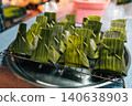 Traditional Asian street food wrapped in eco-friendly green banana leaf packaging 140638903