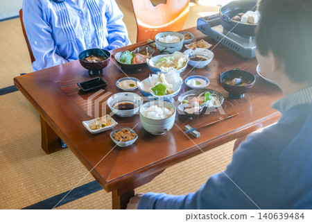 A senior couple enjoys a kaiseki meal in a Japanese-style room at a ryokan (traditional Japanese inn). 140639484